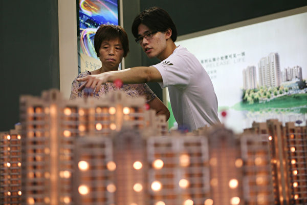 SHANGHAI, CHINA - JULY 11: (CHINA OUT) A salesman introduces property to a potential buyer at the 23rd Shanghai Real Estate Trade Fair And Exhibition on July 11, 2008 in Shanghai, China. Sales Transaction in ten Chinese cities including Beijing, Shanghai, Guangzhou and Shenzhen downed 41 percent averagely in the first half of this year. (Photo by China Photos/Getty Images)